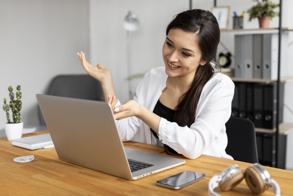 A one-on-one meeting where a woman shows how to do the job by example, as someone practicing the charismatic leadership style in software development.