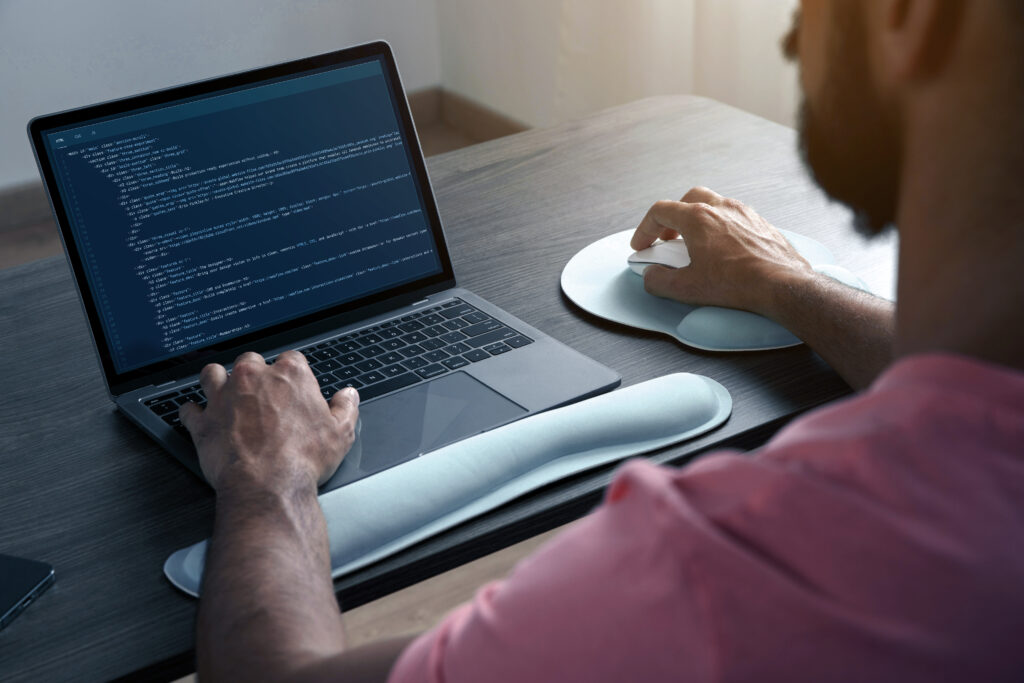 man writing code on his laptop