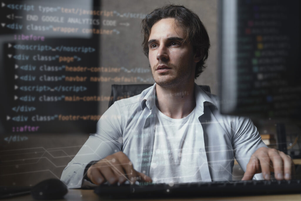 Programmer in front of a computer with a code on the screen.